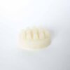 A moisturizing shampoo bar with a unique shape, resembling a piece of a honeycomb, in a soft cream color suggesting its mango scent and rich blend of nourishing oils.